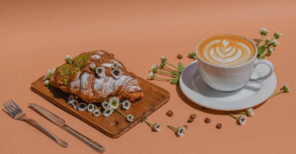 Stylish coffee and croissant setup with flowers and coffee beans on a wooden board.